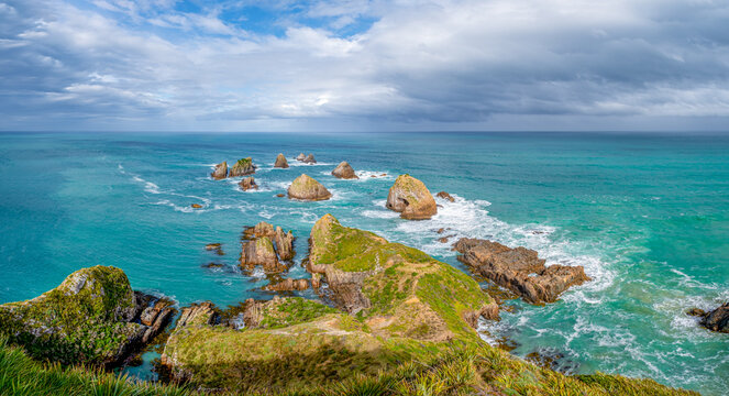 Blick vom Nugget Point Lighthouse auf die Felsstapel The Nuggets im t&uuml;rkisfarbenen Meer, Otago, Neuseeland