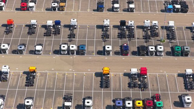 New trucks parked in rows at a manufacturing plant parking lot