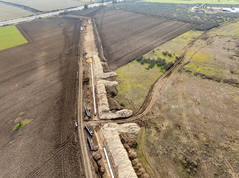 Aerial view of gas and oil pipeline construction. Pipes welded together. Big pipeline is under construction. Energy and fuel transportation industry concept