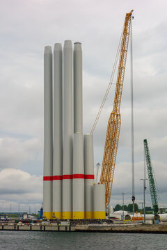 Giant Crawler Crane Assembling Wind Turbine Tower Sections at Port Harbor, Sustainable Offshore Renewable Energy Construction and Logistics