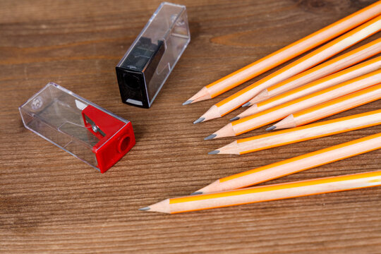 Sharpened Pencils and Manual Pencil Sharpeners on Wooden Table. School Stationery and Creative Workspace Background. Back to School Stationery
