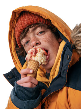 Teenage boy with freckles in an orange winter jacket eating ice cream isolated on transparent or white background, png