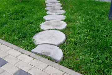 Fototapete Grün Round stepping stone path through green lawn. Concept of eco garden design and yard landscaping pathway. Real Photo.  © LariBat