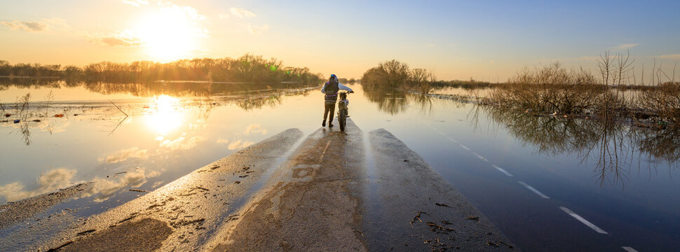 Sunset casts golden light over flooded rural road