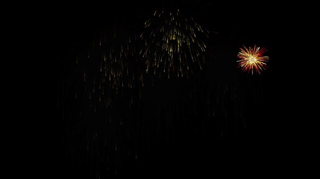 Golden fireworks exploding against black background in dynamic motion video clip with bright glowing sparks