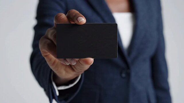 Businesswoman in suit and tie holding a blank black mock up card        