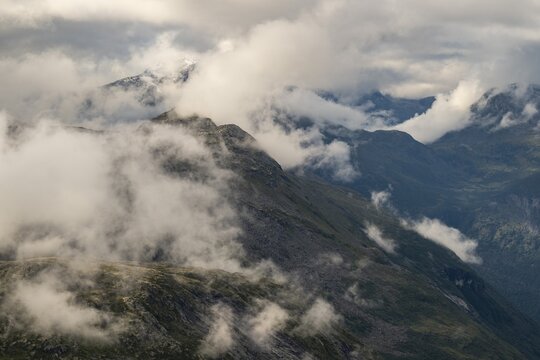 View of mountains lying partly in clouds from the 1476 meter high mountain peak and viewpoint Dalsnibba, Stranda, M&oslash;re og Romdal, Norway