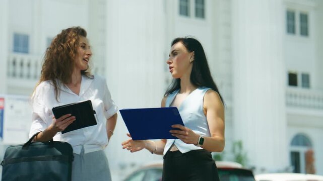 Business individuals meet outdoors to finalize a partnership. Colleagues engage in a positive handshake after their successful discussion.