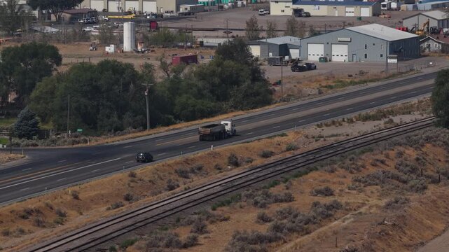 Aerial of industrial corridor with highway and railroad tracks in Burley Idaho on Interstate 84