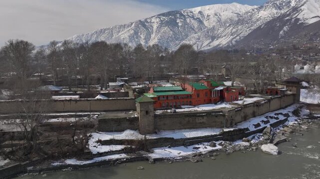 Aerial view in Winter of a historical Fort in Chitral, Pakistan. Bright building along the riverbank in Kalash Valley.