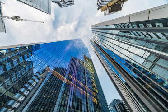 View of modern glass skyscrapers in the City of London reflecting the sky and clouds in London, England, United Kingdom.