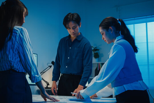 Start up Asia businesspeople meeting plan analysis statistics brainstorm and work with paperwork around table in office conference room at night. Business finance partners strategy investment success.