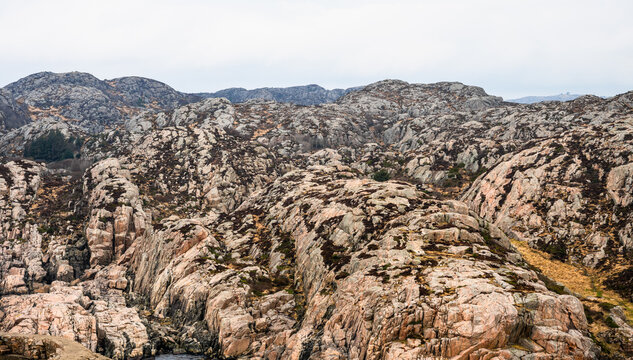 Rocky coastal landscape with barren cliffs under overcast sky.