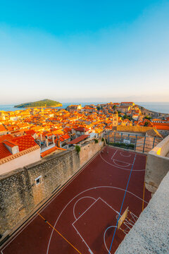Golden hour panorama of Dubrovnik's historic fortifications and old port at dusk, sunlight on ancient stone walls and Mediterranean architecture in Croatia