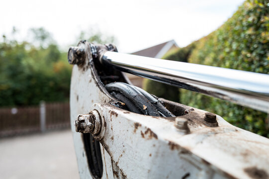 Shallow focus of greased hydraulic pipes seen on a small mechanical digger and scope in a private driveway before being excavated. The single arm piston is visible.