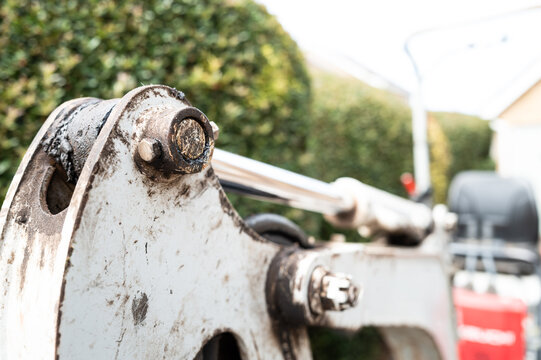 Shallow focus of the hydraulic pivot on a small mechanical single seat digger, used for ground excavation at a house. The seat and digger controllers can just be seen.