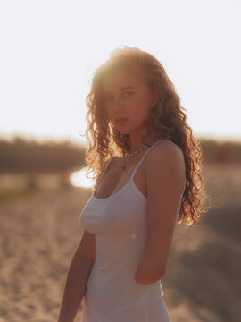 Amputee Woman Standing on Sand Dune in Sunset Backlight