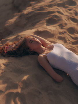 Amputee Woman Lying and relaxing on Sand Dune at Sunset