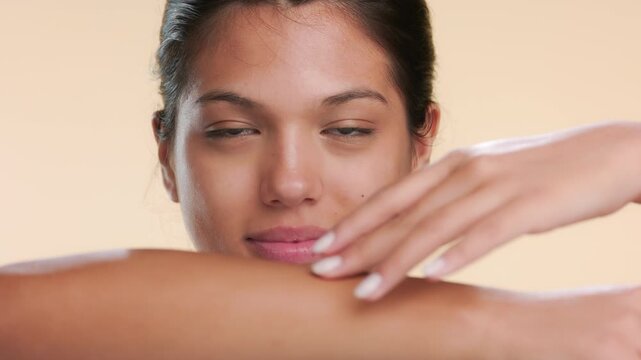 Detailed view of cosmetic model touching her forearm over beige bg | Beauty video revealing unwanted hair removal concept