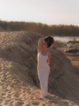 Amputee Woman Standing on Sand Dune at Sunset