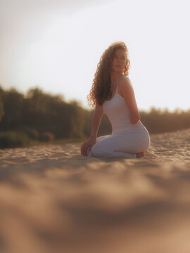 Bottom view of Amputee Woman Kneeling on Sand in Sunset