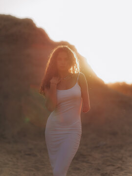 Amputee Woman Standing on Sand Dune at Sunset