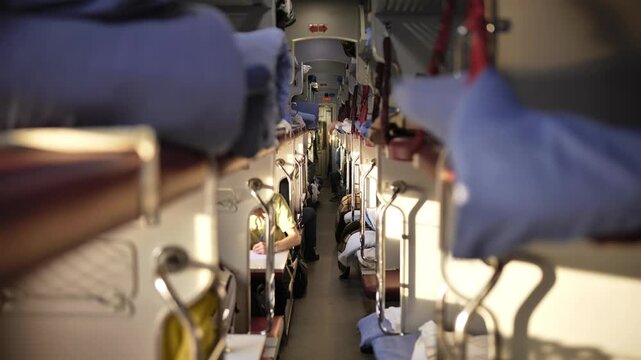 Train sleeper car aisle with passengers traveling long distance on railway journey