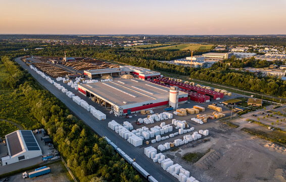 Aerial drone view of large industrial sawmill and timber processing plant with lumber yards during sunset, forestry industry concept