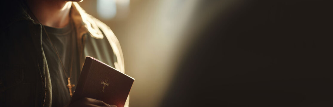 Man standing with bible in hand under light ray in dark church. Religious faith and spiritual devotion concept. Holy belief, prayer time and worship experience in sacred building.