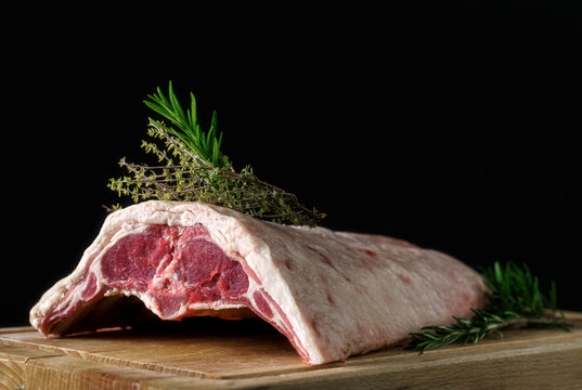 Raw rack of lamb on a wooden board