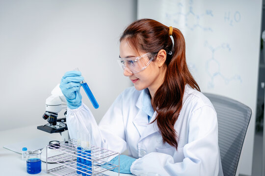 Science professional researches chemicals laboratory examining blue liquid test tube experiment medical healthcare discovery innovation