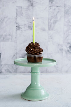Birthday chocolate cupcake with one burning candle