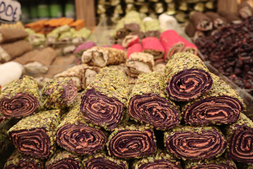 Fototapeta premium Colorful Rolled Turkish Delight Coated with Pistachios at Local Market