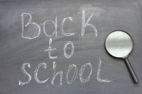 Back to school with magnifying glass on blackboard