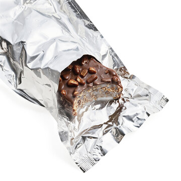 Chocolate bar snack cereal protein treat with nut topping and bite mark cut out on a transparent background for design
