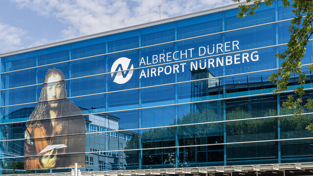 Die verglaste Fassade des Terminalgeb&auml;udes zeigt den Schriftzug 'Albrecht D&uuml;rer Airport N&uuml;rnberg' sowie ein gro&szlig;fl&auml;chiges Portr&auml;t von Albrecht D&uuml;rer als Gestaltungselement.
