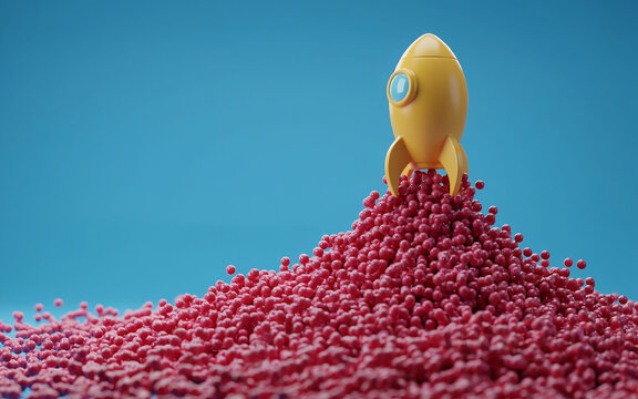 Yellow toy space rocket standing on a mountain of small pink beads against blue background with exploration creativity miniature imagination aspiration colorful abstract discovery