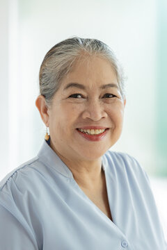 Happy smiling old asian woman, female silver generation person with white hair showing positive friendly expressions, feeling good in home, indoors scene