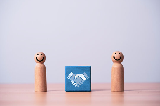 Wooden people with handshake icon symbolize business partnership agreement, collaboration with trust, teamwork, negotiation, cooperation and successful professional relationship concept,