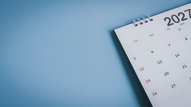 Close up of desk calendar year 2027 on blue background with copy space for planning concept.