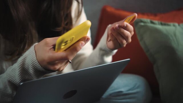 Young Latina woman focused on online shopping from her sofa during Cyber Monday, carefully browsing products and comparing deals from the comfort of home.
