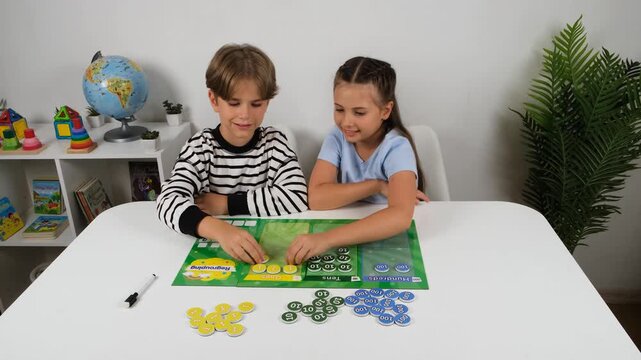 Professional 4k video clip of two young students interacting with educational math counting board. Cute boy and girl practicing numbers at home for early learning and STEM media.