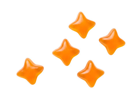 Five brightly colored orange star shaped gummy candies are scattered in a random pattern on a plain white background with transparency