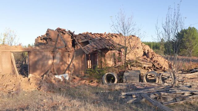 Old adobe house in ruins, located in a rural landscape of Chile, evoking history, abandonment, and the passage of time in traditional architecture.