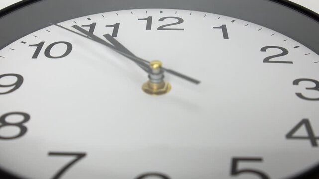 4K Extreme modern black round wall clock showing five minutes to 11 o'clock, deadline time running out, countdown, last minute and time management.