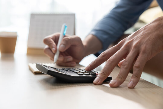 Hand calculator pen finance accounting desk paper office business work close up of person writing notes and pressing calculator keys during financial planning on wooden table