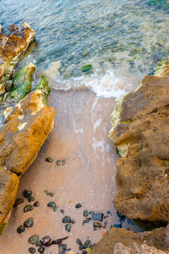 rock texture at the sea. ocean coast background. transparent water. calm wave and seaweed