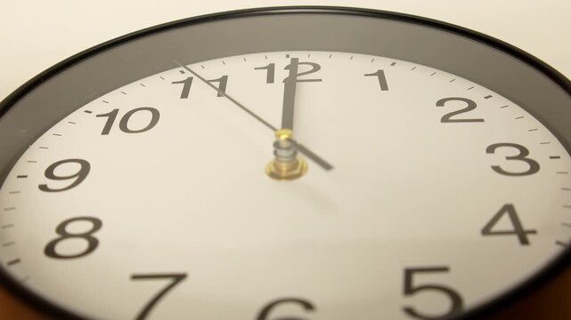 4K High angle close-up shot of black round wall clock showing exactly twelve o'clock, deadline noon midnight time management lunch time and new starting point.