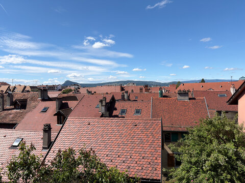 A picturesque view of a small town with red roofs under a blue sky