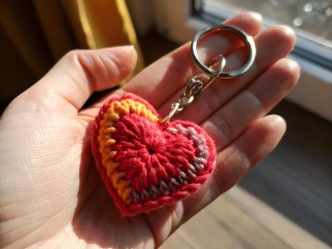 Red yarn crocheted heart keychain isolated on transparent background for decor and branding